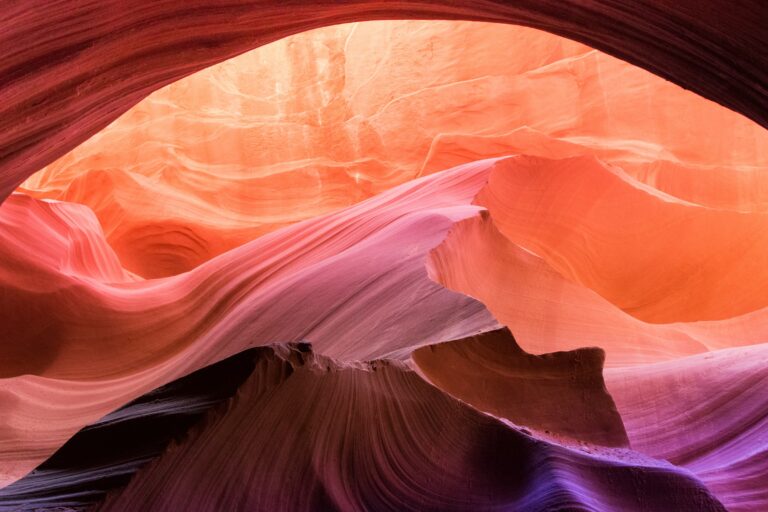 Abstract view at Antelope Canyon - Orange, Pink, Violet curving rock formations fill the frame.